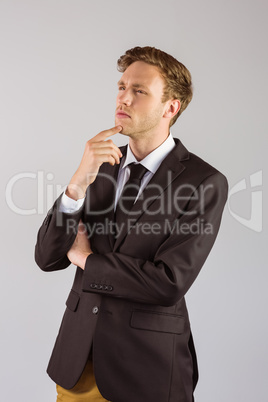 Young businessman thinking with hand on chin