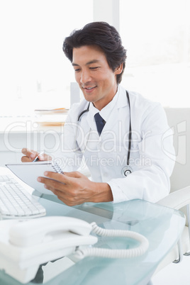 Happy doctor writing down notes