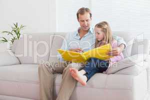 Casual father and daughter looking at photo album