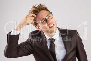 Young geeky businessman scratching his head