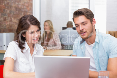 Happy business team looking at computer screen together