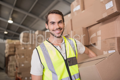 Worker carrying box in warehouse