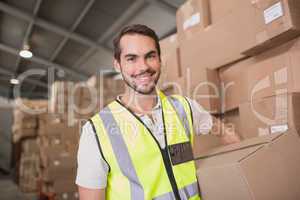 Worker carrying box in warehouse