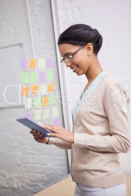 Businesswoman smiling while touching a tablet computer