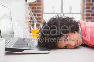 Casual businesswoman resting head on desk