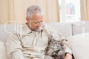 Happy man with his pet cat on sofa