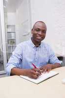 Portrait of a smiling businessman writing notes