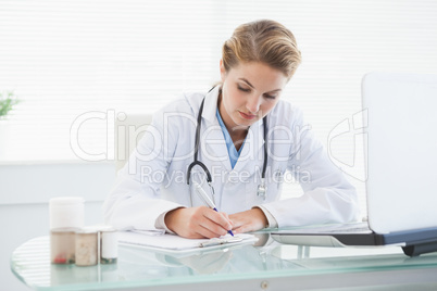 Doctor filling out prescriptions