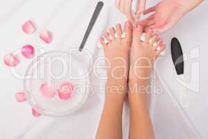 Beautician painting womans toenails