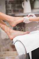 Woman getting a pedicure from beautician