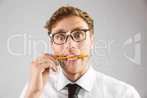 Geeky businessman biting a pencil