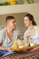 Cute couple having breakfast in bed