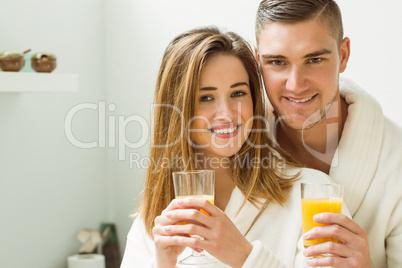 Couple drinking orange juice in bathrobes