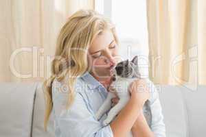 Pretty blonde with pet kitten on sofa