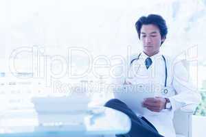 Focused doctor reading over notes