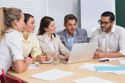 Casual business team having a meeting using laptop