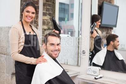 Hair stylist and client smiling at camera