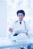 Focused doctor reading over notes