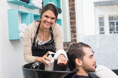 Hair stylist putting conditioner in mans hair