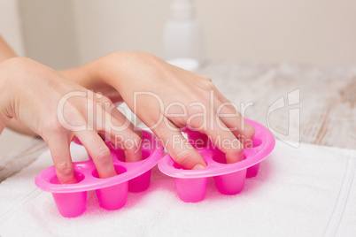 Woman soaking her nails in nail bowls