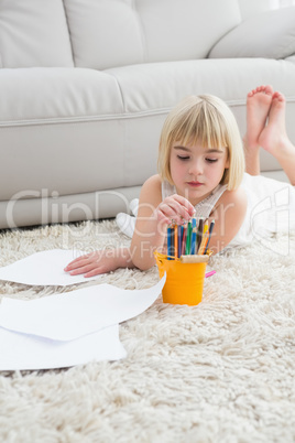 Smiling litlle girl drawing lying on the floor