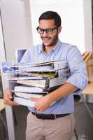 Businessman carrying stack of folders