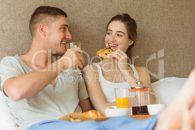 Cute couple having breakfast in bed