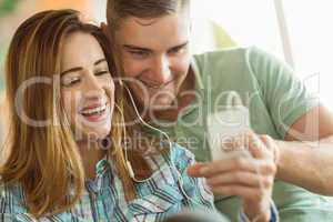 Cute couple relaxing on couch with smartphone