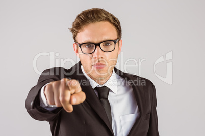 Young serious businessman pointing at camera