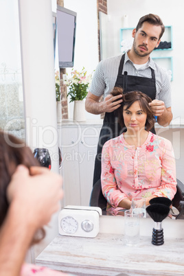 Handsome hair stylist with client