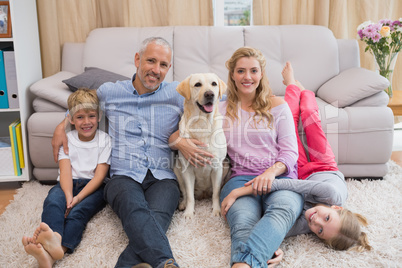 Parents and children on rug with labrador