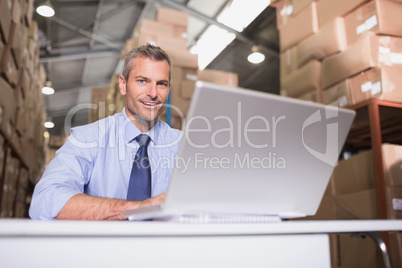 Portrait of warehouse manager with laptop