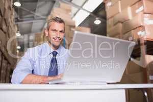 Portrait of warehouse manager with laptop