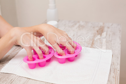 Woman soaking her nails in nail bowls