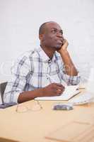 Portrait of a smiling man thinking at his desk