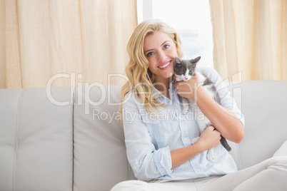 Pretty blonde with pet kitten on sofa