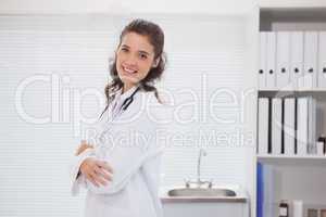 Smiling brunette doctor standing alone