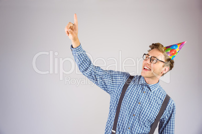 Geeky hipster wearing party hat pointing