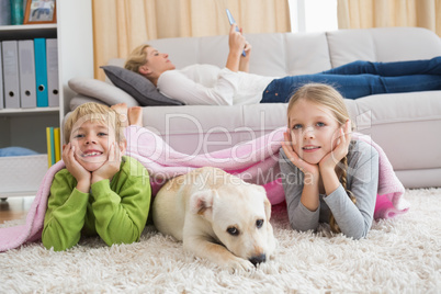 Cute silblings with their puppy on rug