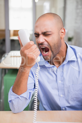 Angry businessman using telephone