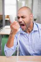 Angry businessman using telephone