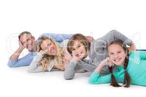 Smiling family lying on the floor in row