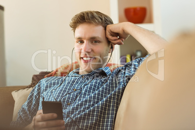 Young man listening to music on his couch