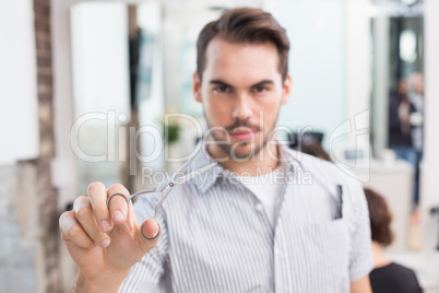 Handsome hair stylist holding scissors