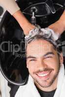 Hair stylist washing mans hair