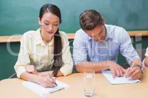 Focused business people taking notes during presentation