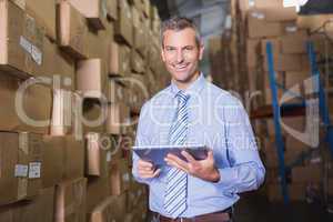 Male manager using digital tablet in warehouse