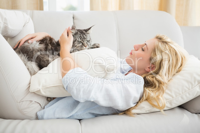 Happy blonde with pet cat on sofa