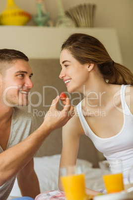 Cute couple having breakfast in bed