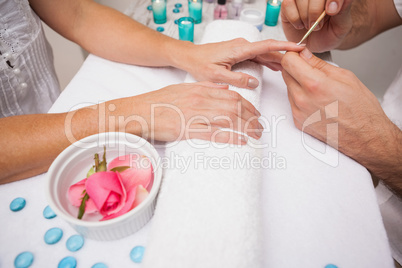 Manicurist cleaning a customers nails